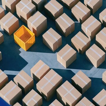 Kraft parcel boxes arranged in a geometric pattern for holiday shopping and seasonal sale orders, featuring a single yellow accent tote