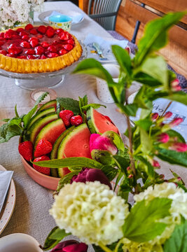 Frische Wassermelone und Erdbeeren mit Minze auf sommerlich gedecktem Tisch