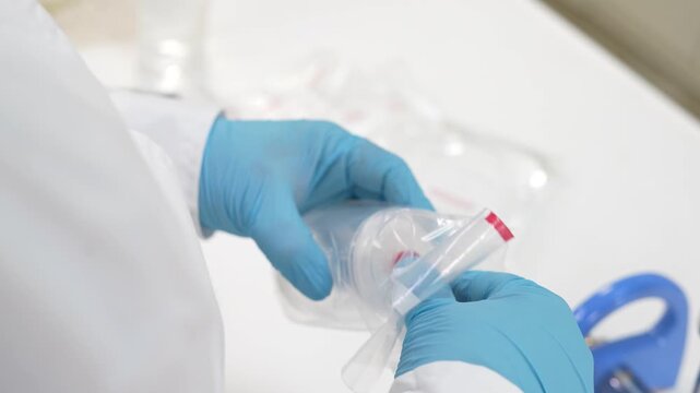 Scientist taking sterile membrane filter unit out of packaging and placing it on vacuum manifold