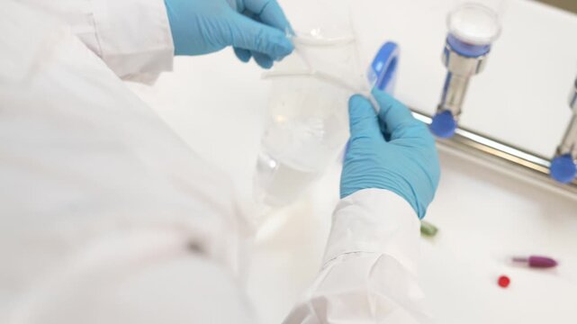 Scientist filling disposable filter cup with water sample and covering it on filtration manifold