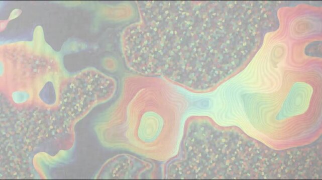 Abstract light patterns flowing across textured surface with rainbow hues during soft ambient illumination