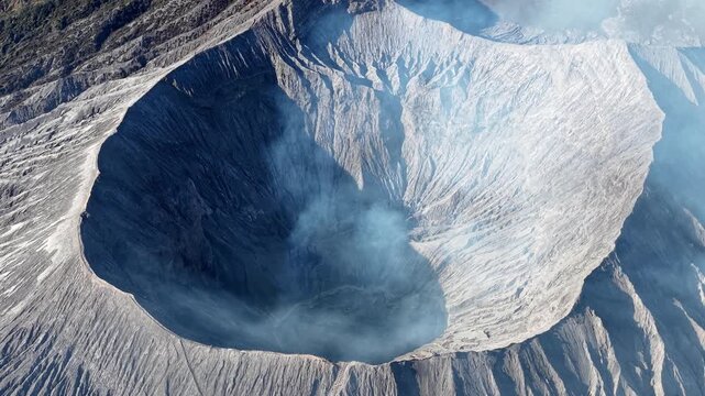 Volcanic crater opens wide, steaming softly above. Rugged slopes surround a deep, active caldera at Bromo