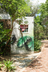 Mural of leaves and a bird painted on a brick building © Dylan