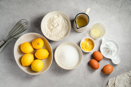 Lemon cake ingredients on a grey background, baking concept, top view with copy space