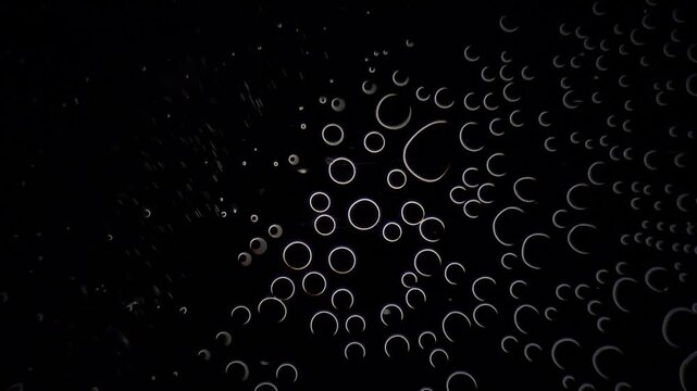 Hydrogen peroxide reaction creating oxygen bubbles under darkfield microscopy background 
