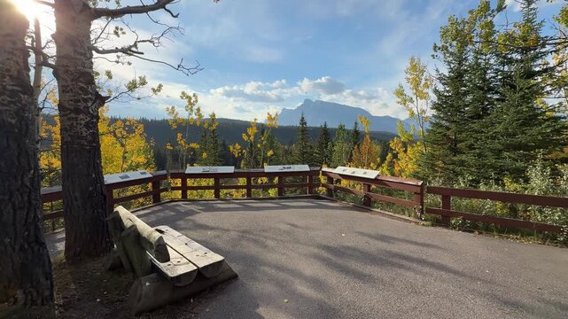 Wooden observation deck at Mount Rundle Overlook surrounded by autumn trees with view of Mount Rundle, Banff National Park, Alberta, Canada