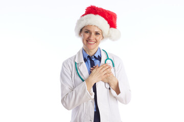 A female physician in festive attire smiles with hands clasped together, conveying warmth, empathy, and holiday greetings from a professional medical clinic. © Alliance