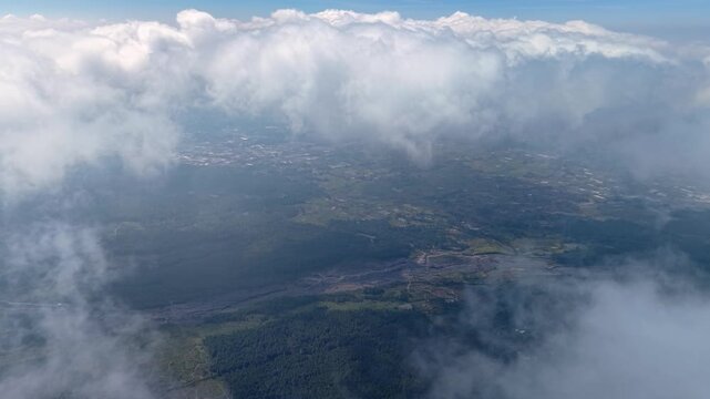 Clouds drift above a hidden valley. Landmasses peek through foggy layers at Pronojiwo, Lumajang
