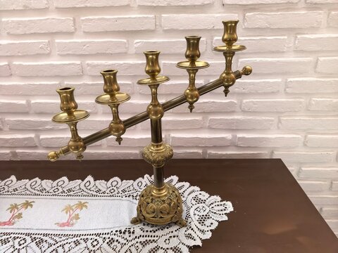Vintage candlestick with an old white wall background, classic interior decor detail.