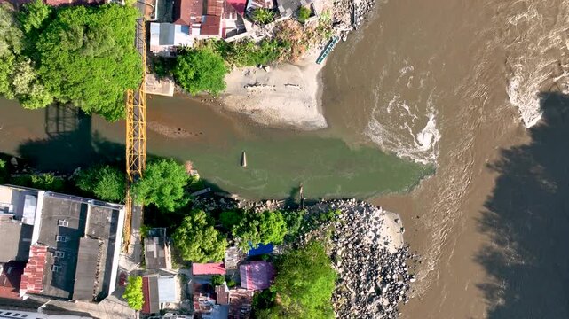Honda at the Confluence of the Gual&iacute; and Magdalena Rivers with Contrasting Water Colors in Colombia. Establishing Shot. Aerial View.