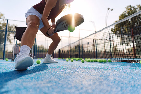 Close up of athletic woman practicing paddle tennis on outdoor court.