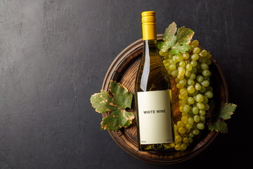 Naklejka premium Wine bottle nestled beside a ripe green grape cluster