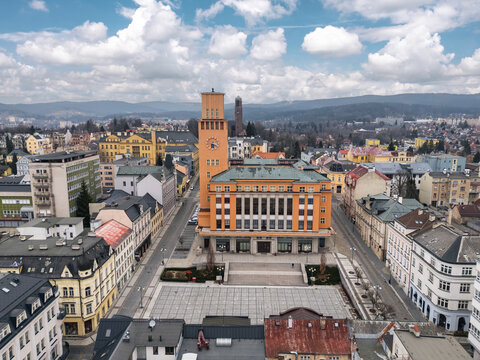 Aerial view of the New Town Hall and Peace Square in Jablonec nad Nisou, Liberec Region, Czech Republic, with the historic center and wooded hills under a bright sky.