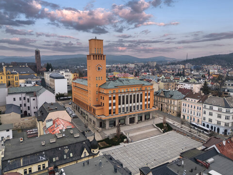 New Town Hall and Peace Square in Jablonec nad Nisou, Liberec Region, Czech Republic, viewed at dusk with pastel clouds, city rooftops and wooded hills.