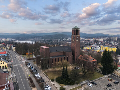 Aerial view of the Church of the Sacred Heart of Jesus in Jablonec nad Nisou, Liberec Region, Czech Republic, with the surrounding streets, parking area and hills.