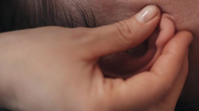 Relaxing ear massage technique for wellness in a calming environment