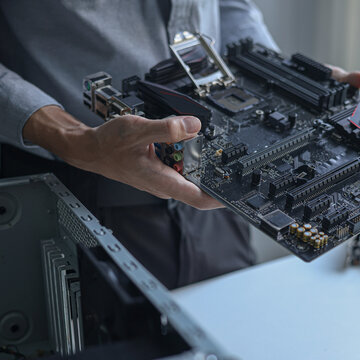 Computer engineer repairing computer motherboard and hardware components.