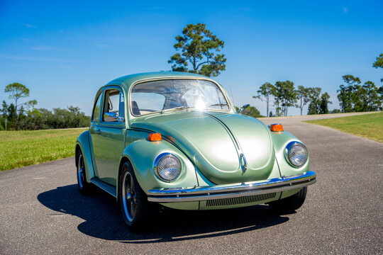 Green color 1971 VW Bug Beetle in an outdoor park setting