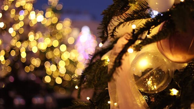 Cinematic close-up of a Christmas tree with a clear glass ball, white ribbon and warm string lights, golden bokeh and blue twilight sky, festive holiday concept