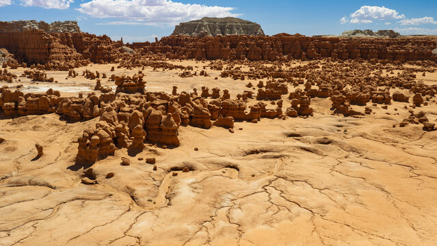 An aerial view of the Valley of the Goblins inside Goblin Valley State Park, Utah. A dried up creek bed creates a lightning-like design in the sand and clay, surrounded by hordes of "goblins."