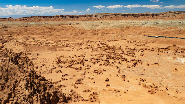 Aerial view of the Valley of the Goblins inside Goblin Valley State Park, UT. The parking lot (on the right) overlooks the valley. Towering walls separate the valley from the Goblin's Lair.