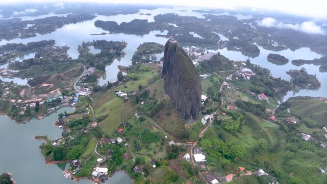 Guatap&eacute; and Iconic Piedra del Pe&ntilde;ol Surrounded by Reservoir Islands and Mountains in Colombia. Establishing Shot. Aerial View.