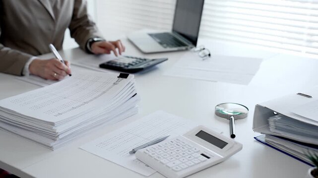 Businesswoman hands organizing stack of papers with binder clips, working on financial documents and official reports in office. Audit and taxes concept