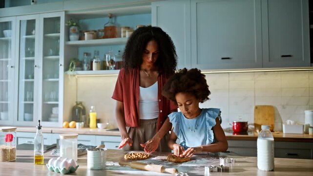 Mom teaching child knead dough home kitchen. Multiracial family baking cookies.