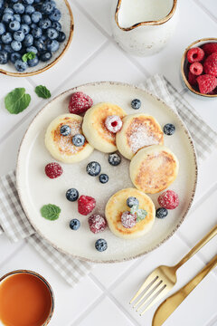 Cottage cheese pancakes with fresh blueberries, raspberries and mint on a plate