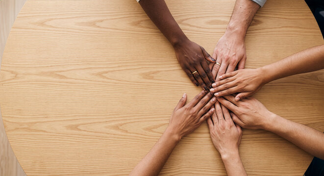 Teamwork and diversity in business: flat lay of multiethnic hands united on table