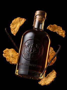 Aged Caribbean rum bottle with floating dried pineapple and vanilla
