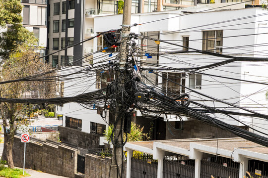 Utility pole tangled with many electric wires