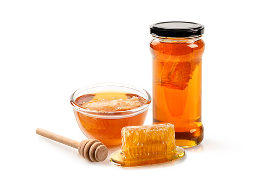 Collection of organic honey in glass jar and bowl of fresh honeycomb, and wooden dipper isolated on white background.