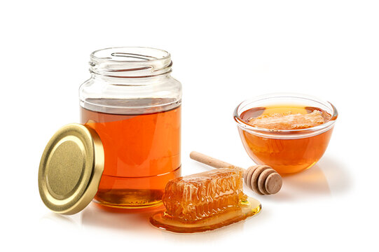 Collection of organic golden honey featuring an open glass jar, a bowl with honeycomb, and wooden dipper. Professional food photography isolated on white background.