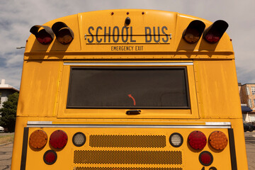 Rear View of Yellow School Bus with Emergency Exit and Safety Lights © Ian