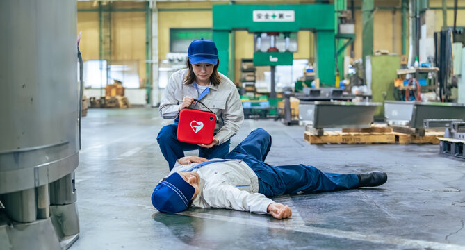 A worker uses an AED to help a man who collapsed in the factory.