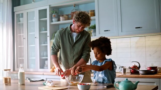 Mixed race family cooking breakfast kitchen. Father daughter grinding spices.