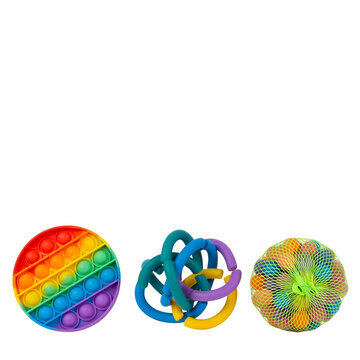 Three colorful sensory fidget toys isolated on white background including rainbow pop it circle, intertwined colorful rings and rainbow spiky mesh ball for kids stress relief and autism therapy.
