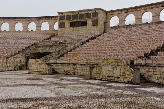 Roman-style stone amphitheatre seating and an arched wall