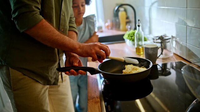 Father frying omelette pan home kitchen. Daughter waiting breakfast closeup.