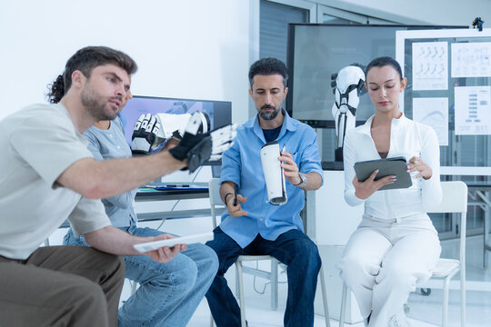 Embodied intelligence testing: an engineer slides the outer shell along the worn robot forearm while the wearer holds his arm out straight to keep the line true