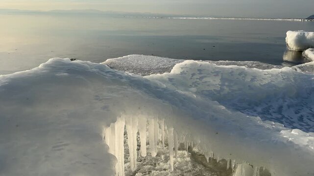 Video of Baikal Lake in December. Waves wash up ice mounds known as Sokui onto beach, shores become covered with whimsical ice crusts and icicles. Unusual waterscape. Changing of seasons