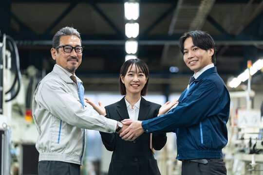 工場内で握手する作業員。事業承継、M&A、後継者、仲介、紹介、産業、製造業、町工場、請負、引き継ぎ