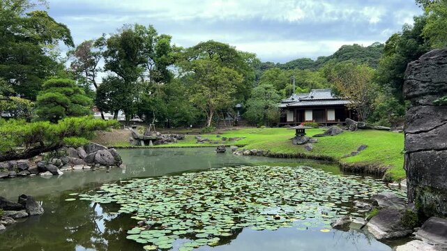 巨石と睡蓮の池越しに茶室を望む旧島津氏玉里邸庭園