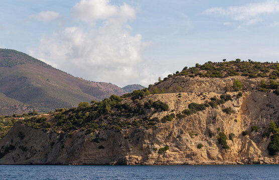 The coastline of Thassos Island. The marine landscape in Greece. Rocks, sea, trees, sky.