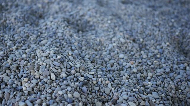 Camera pans across rocks and pebbles on the ground