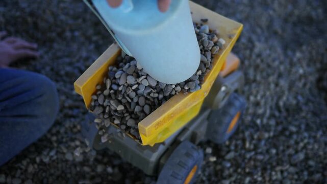 Cinematic Shot of Boy Loading Rocks into Play Dump truck
