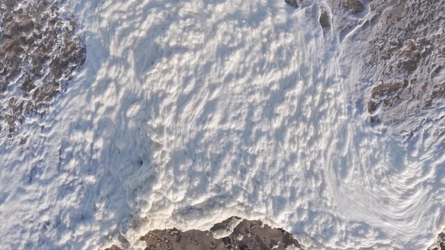 Algal Bloom Thick sea foam covering a sandy beach aerial
