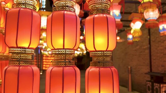 Glowing red Chinese New Year lanterns hanging in rows along a traditional alleyway at night