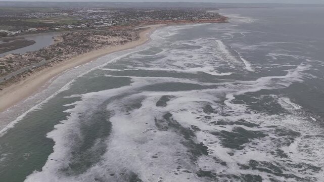 Algal Bloom Thick sea foam covering a sandy beach aerial
